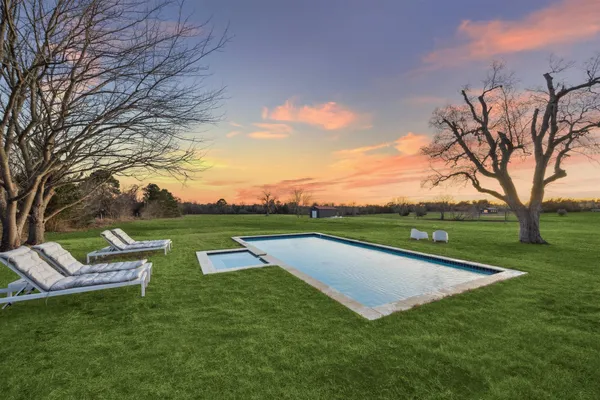 a view of a swimming pool and trees in the background