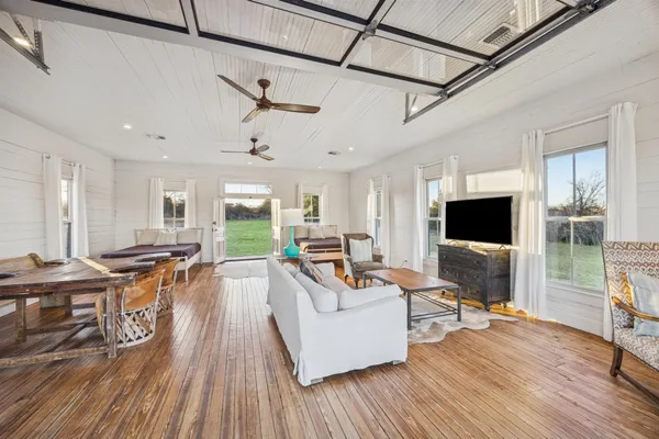 a living room with furniture a flat screen tv and a large window