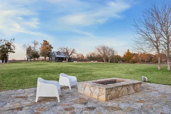 a view of a big house with a big yard and large trees