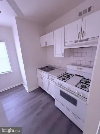 a kitchen with white cabinets and white appliances
