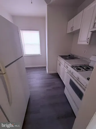 a kitchen with granite countertop a stove and a refrigerator