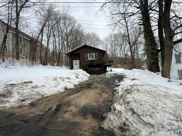 a front view of a house with a yard covered in snow