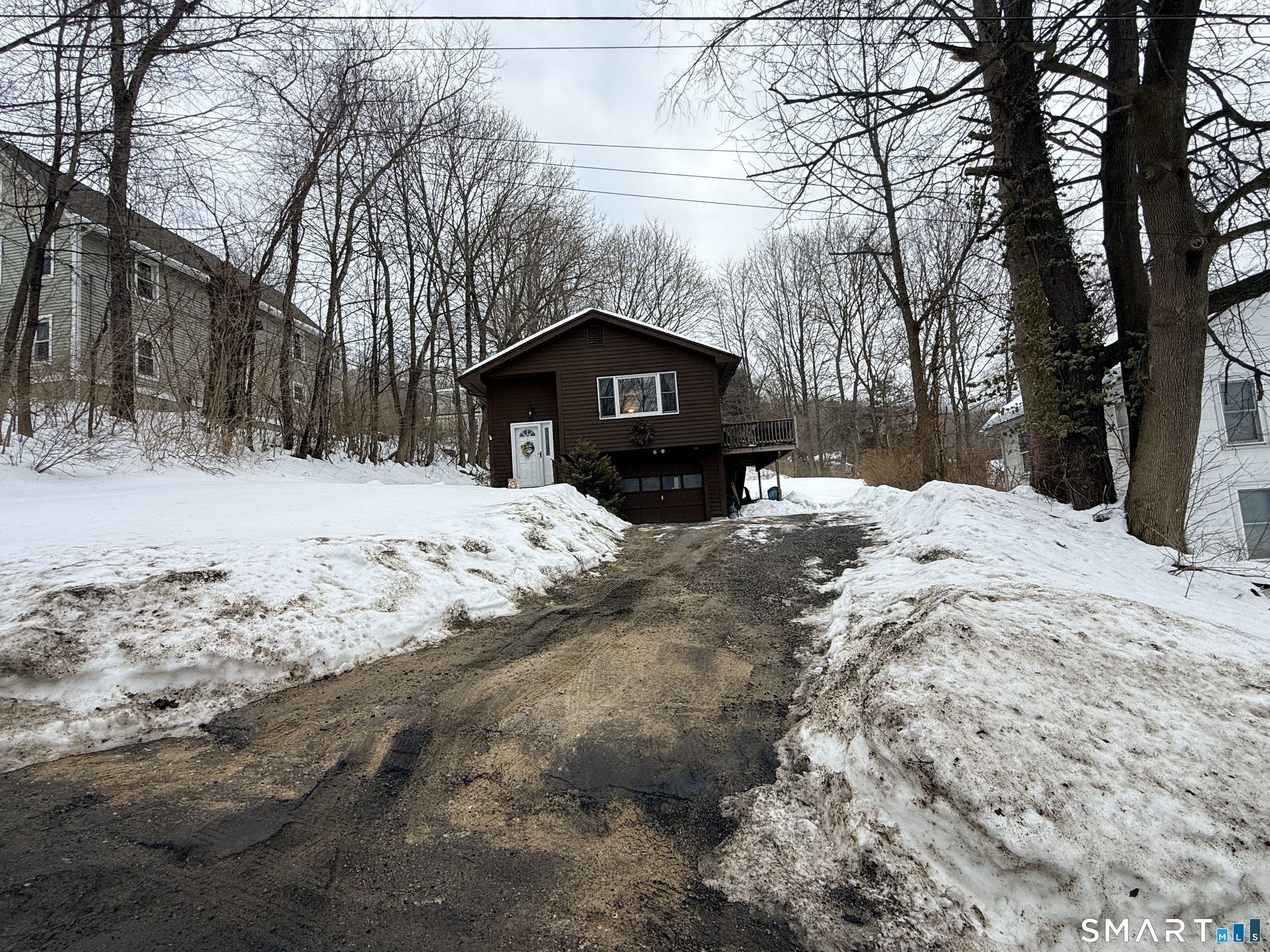 a front view of a house with a yard covered in snow