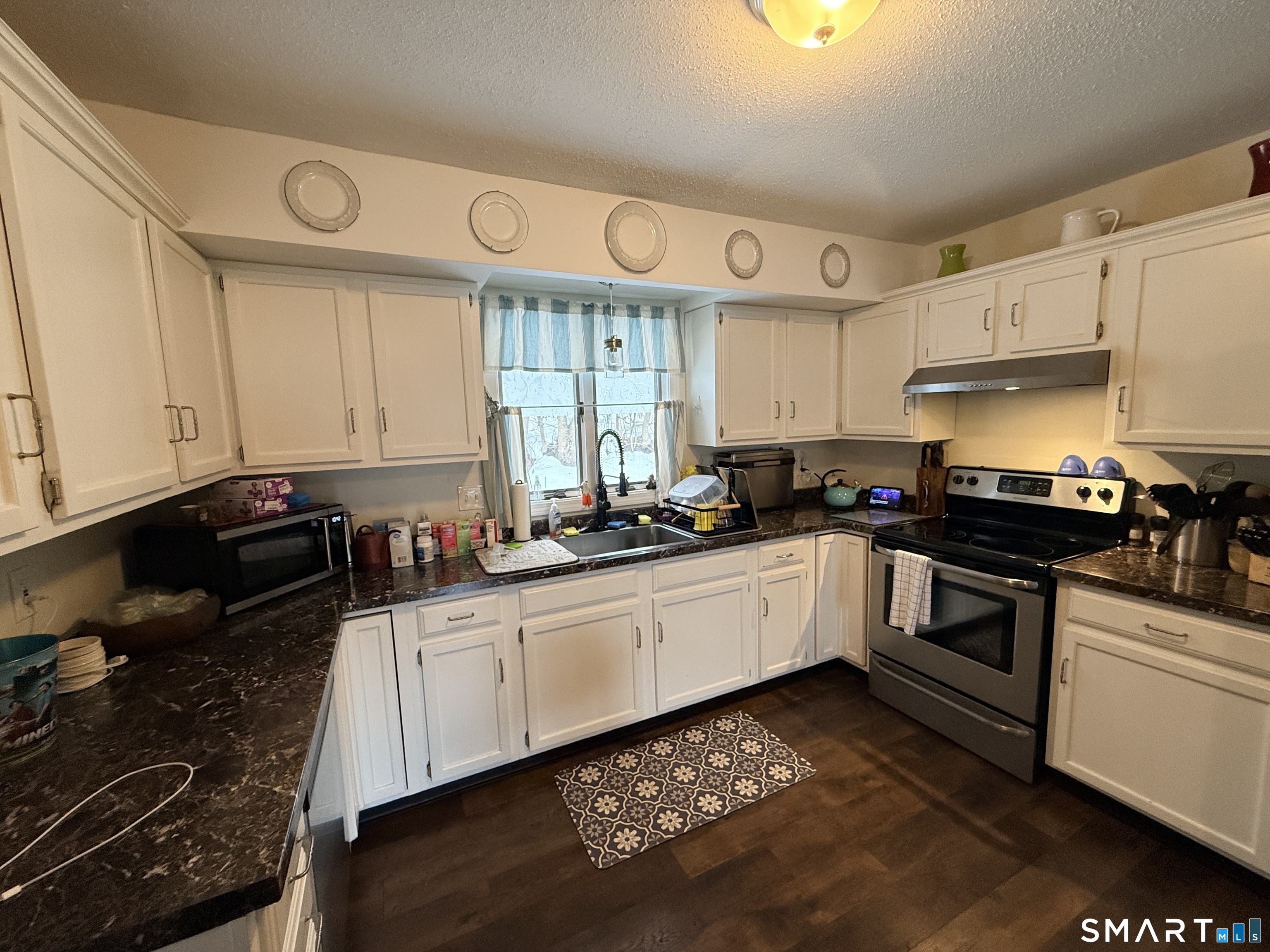44 Lewis Street Winchester, CT 06098 - Photo 16 of 25 a kitchen with a sink stove and cabinets