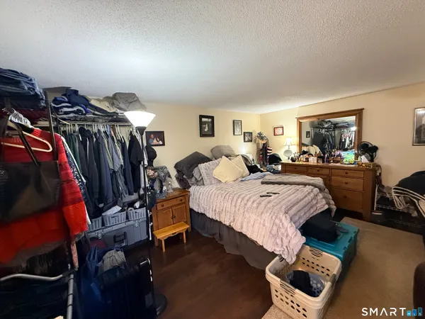a bedroom with a bed a closet and flat screen tv