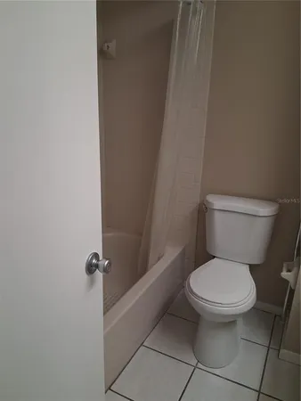 a white toilet sitting next to a shower