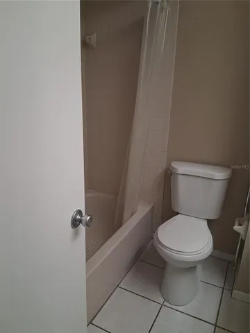 a white toilet sitting next to a shower
