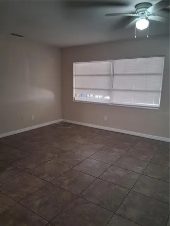 a view of an empty room with a chandelier fan