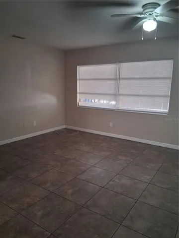 a view of an empty room with a chandelier fan