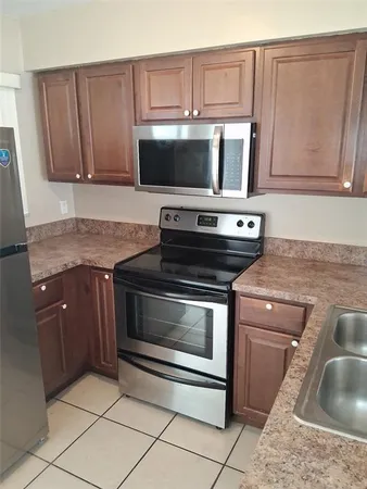 a kitchen with granite countertop a stove top oven microwave and cabinets