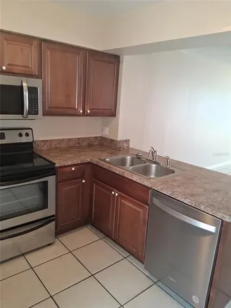 a kitchen with granite countertop cabinets stainless steel appliances and a sink