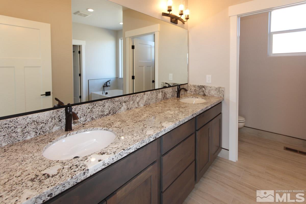 5077 Conte Drive Carson City, NV 89701 - Photo 20 of 40 a bathroom with a granite countertop sink and a mirror