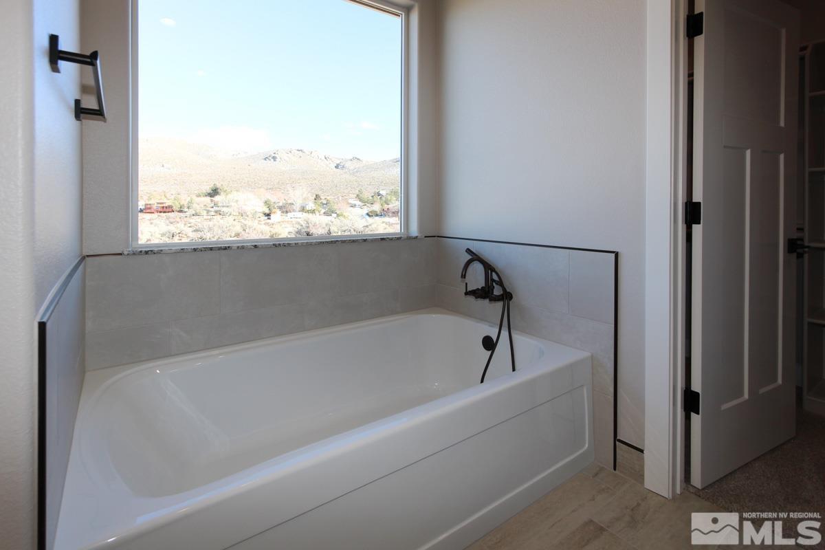 5077 Conte Drive Carson City, NV 89701 - Photo 22 of 40 a white bath tub sitting in a bathroom next to a window