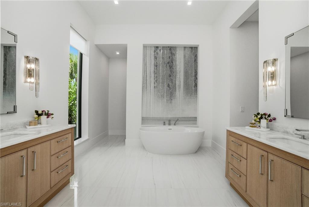 264 8th Avenue South Naples, FL 34102 - Photo 12 of 40 a bathroom with a double vanity sink toilet and mirror