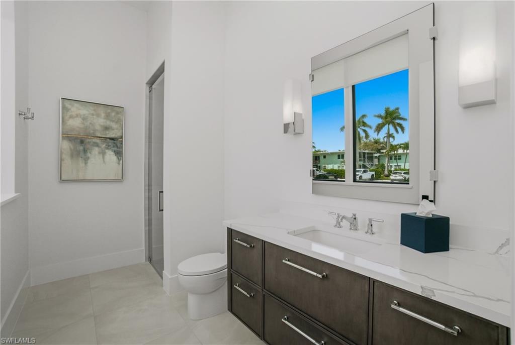 264 8th Avenue South Naples, FL 34102 - Photo 16 of 40 a bathroom with a toilet sink and mirror