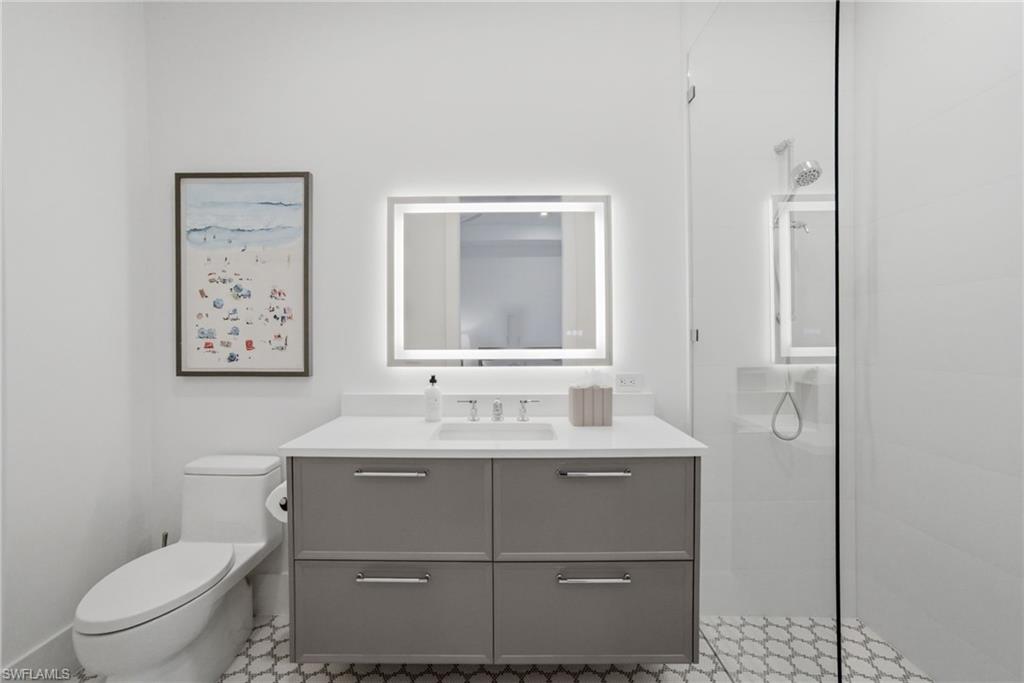 264 8th Avenue South Naples, FL 34102 - Photo 23 of 40 a bathroom with a toilet sink and mirror