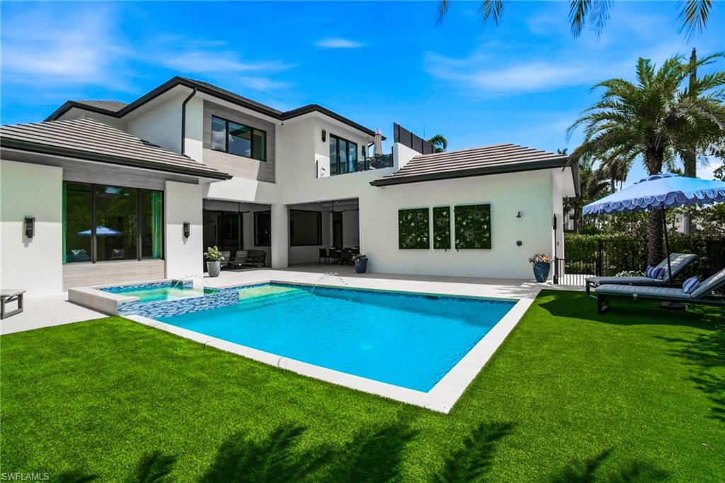 264 8th Avenue South Naples, FL 34102 - Photo 30 of 40 a view of a house with a swimming pool and a yard
