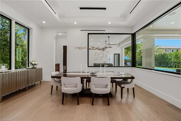 a room with lots of furniture a large window and a table