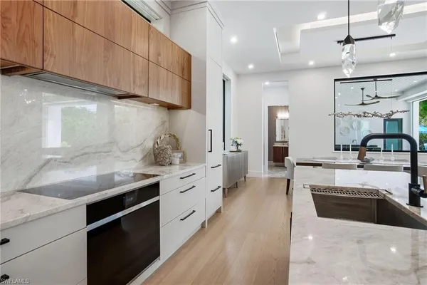 a large kitchen with stainless steel appliances kitchen island granite countertop a sink a stove and cabinets