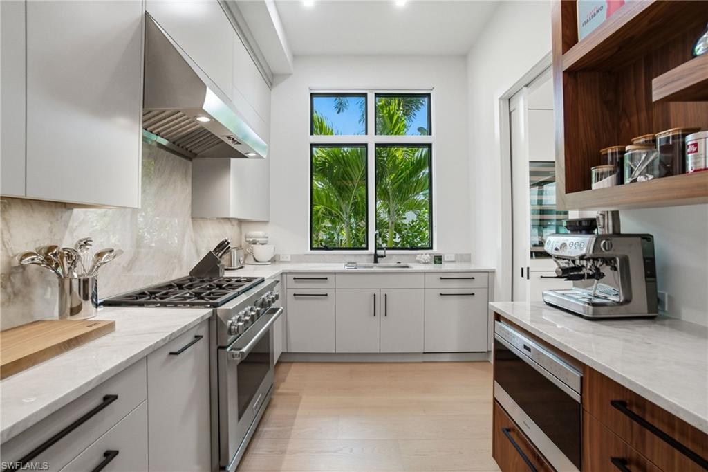264 8th Avenue South Naples, FL 34102 - Photo 9 of 40 a kitchen with a sink stove top oven and cabinets