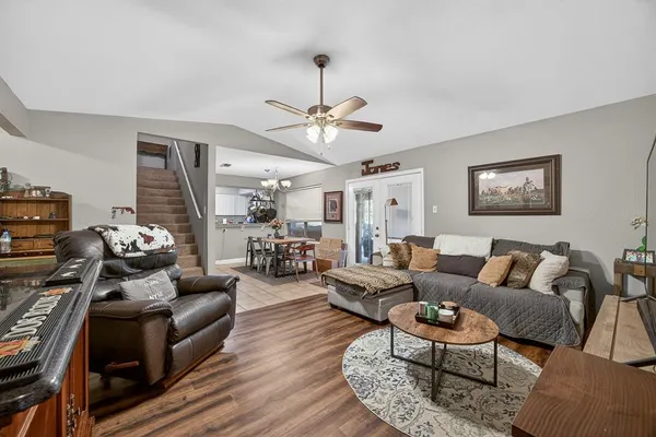 a living room with furniture ceiling fan and a wooden floor