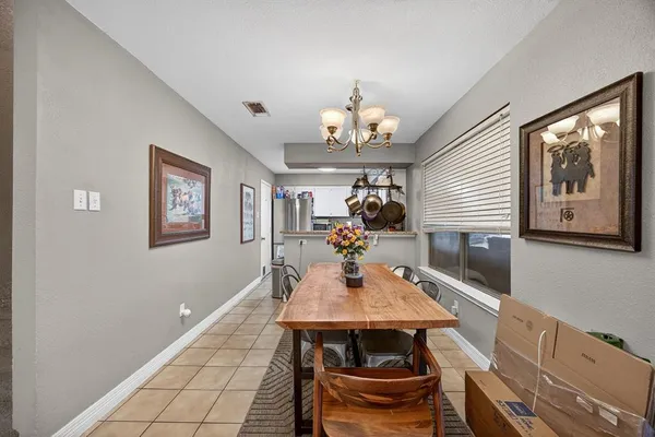 a view of a dining room with furniture a chandelier and wooden floor