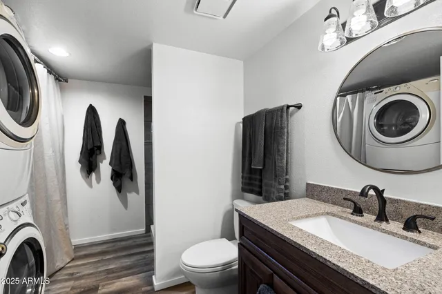 a bedroom with a bed a large window and wooden floor