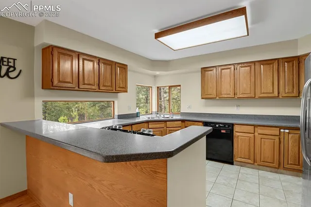 a large kitchen with stainless steel appliances kitchen island granite countertop a refrigerator and a stove top oven