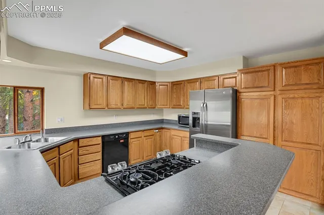 a kitchen with stainless steel appliances granite countertop a stove a sink and a refrigerator