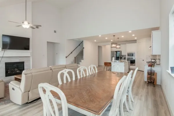 a kitchen with stainless steel appliances granite countertop a sink dishwasher a stove refrigerator and white cabinets with wooden floor