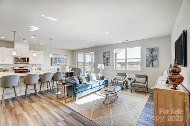 a living room with furniture and a flat screen tv with wooden floor
