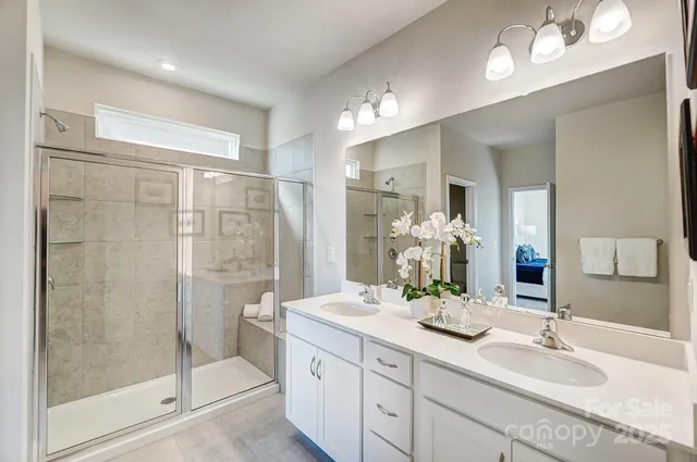 a bathroom with a double vanity sink mirror and shower