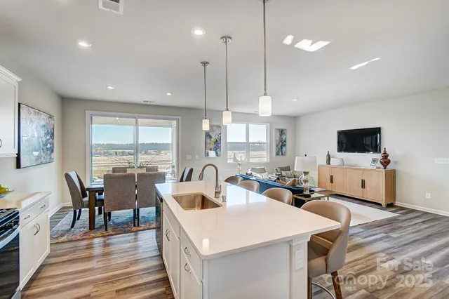 a large kitchen with a table chairs and flat screen tv