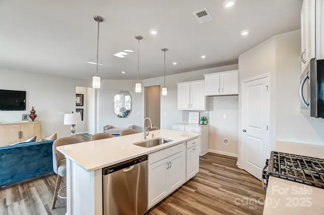 a large white kitchen with a sink a refrigerator and a stove