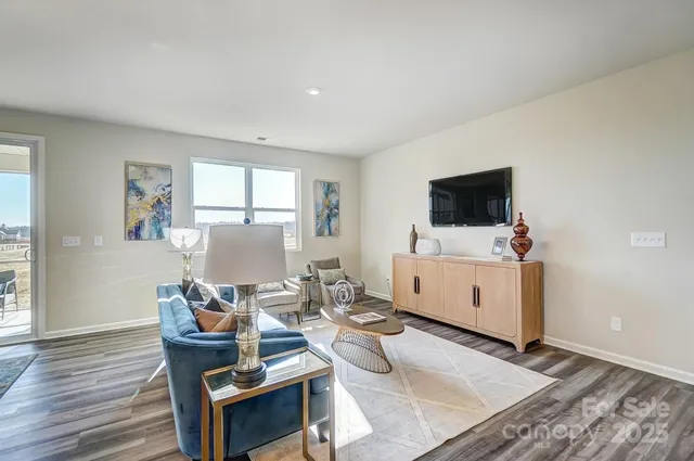 a living room with furniture a flat screen tv and a window
