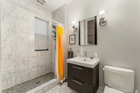 a bathroom with a sink a toilet and shower