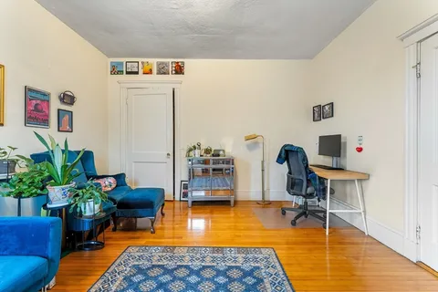 a living room with furniture a rug and a table