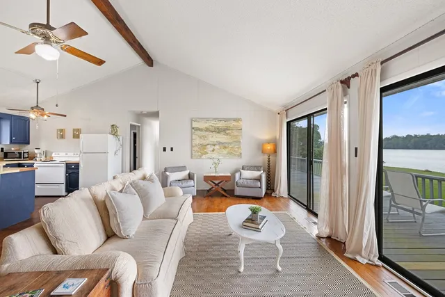 a living room with furniture kitchen view and a window