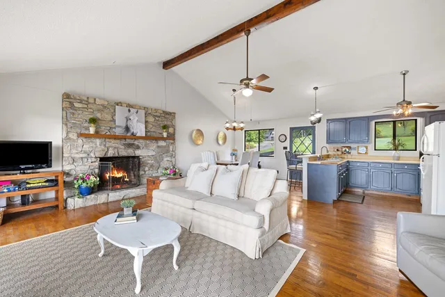 a living room with furniture kitchen view and a fireplace