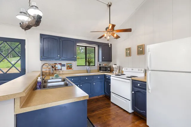 a kitchen with a stove a sink a center island and cabinets