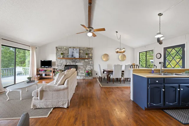 a living room with furniture a fireplace and a large window