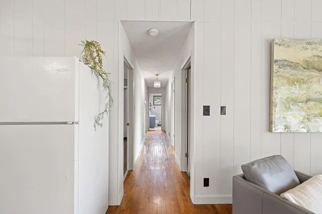 a view of a hallway with wooden floor and glass door