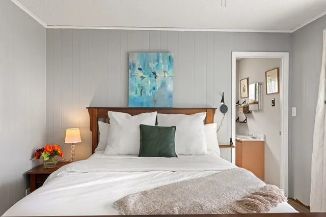 a bedroom with a bed and a painting on the wall