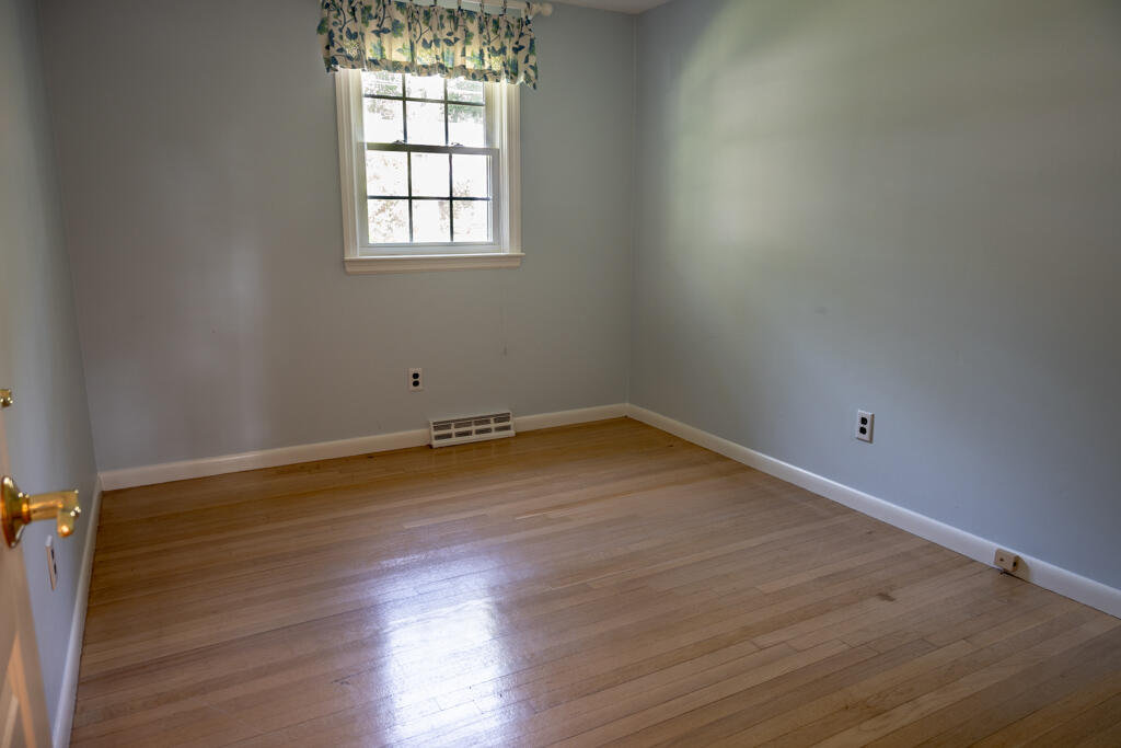 76 Longfellow Drive Centerville, MA 02632 - Photo 10 of 18 an empty room with wooden floor and windows
