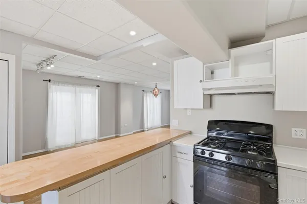 a kitchen with granite countertop a stove and a white cabinets