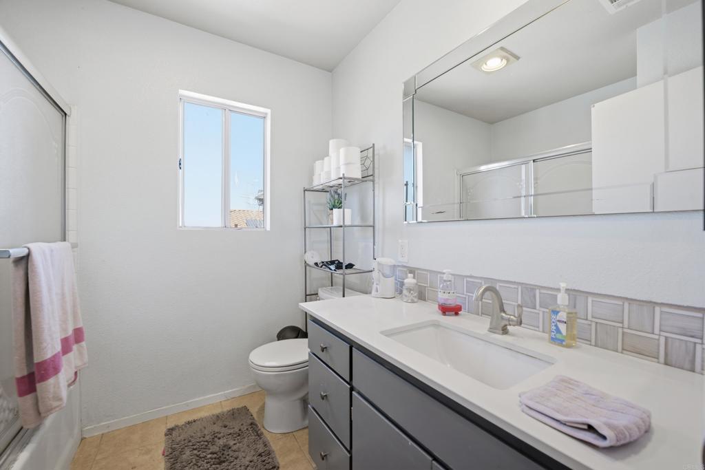 2077 Westwood Road Vista, CA 92083 - Photo 26 of 37 a bathroom with a granite countertop sink a toilet and a mirror