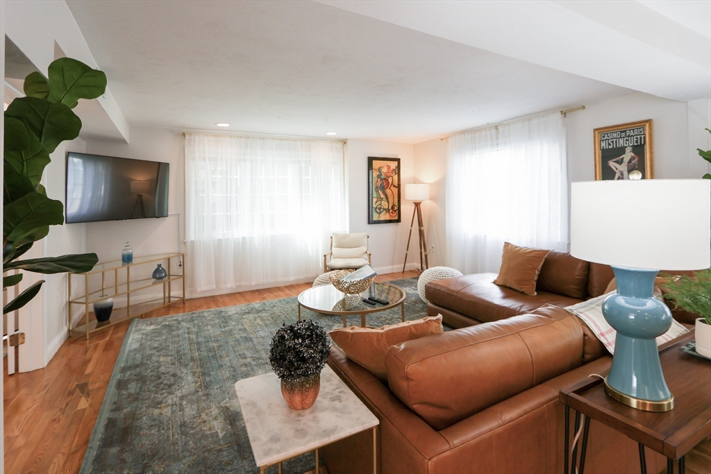 a living room with furniture a wooden floor and a flat screen tv