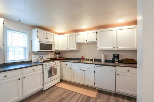a kitchen with cabinets stainless steel appliances a sink and a window