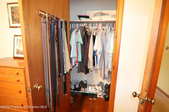 a view of walk in closet with clothes and shoes
