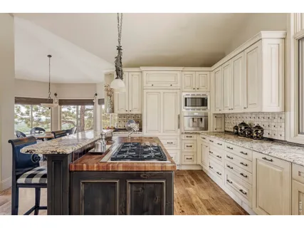 a kitchen with granite countertop a stove a sink and a refrigerator